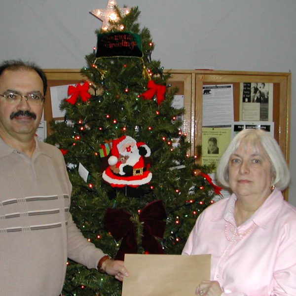 Lion Myron Spektor presenting Holiday Food Certificates to Connie P. for needy families of the community