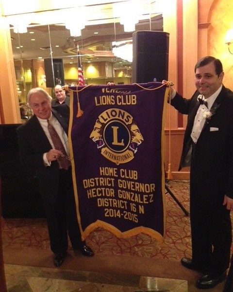 Past VLC President Frank Riccardi presents banner to VLC member and District 16N Governor Hector Gonzalez